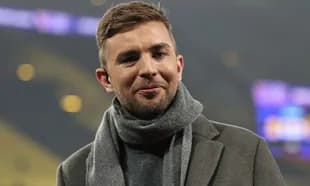 Man smiling, wearing a coat and scarf