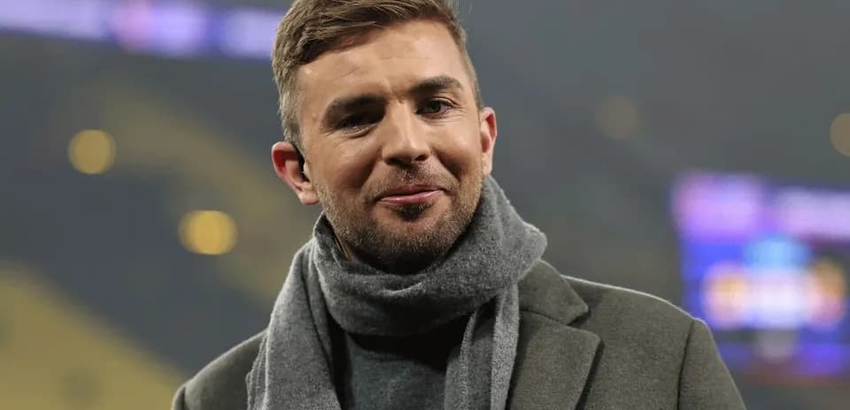 Man smiling, wearing a coat and scarf