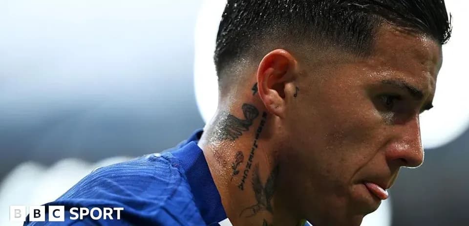 Football player with tattoos looking down
