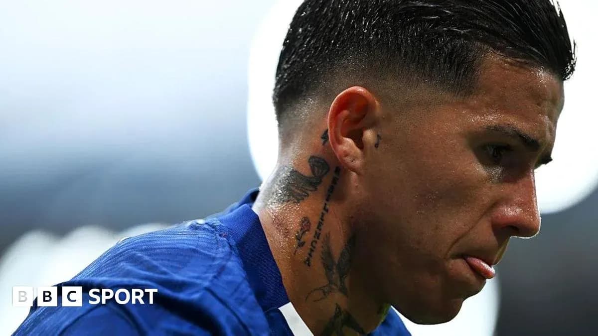 Football player with tattoos looking down