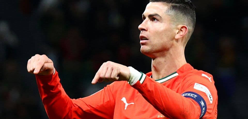 Player gesturing during match in orange jersey