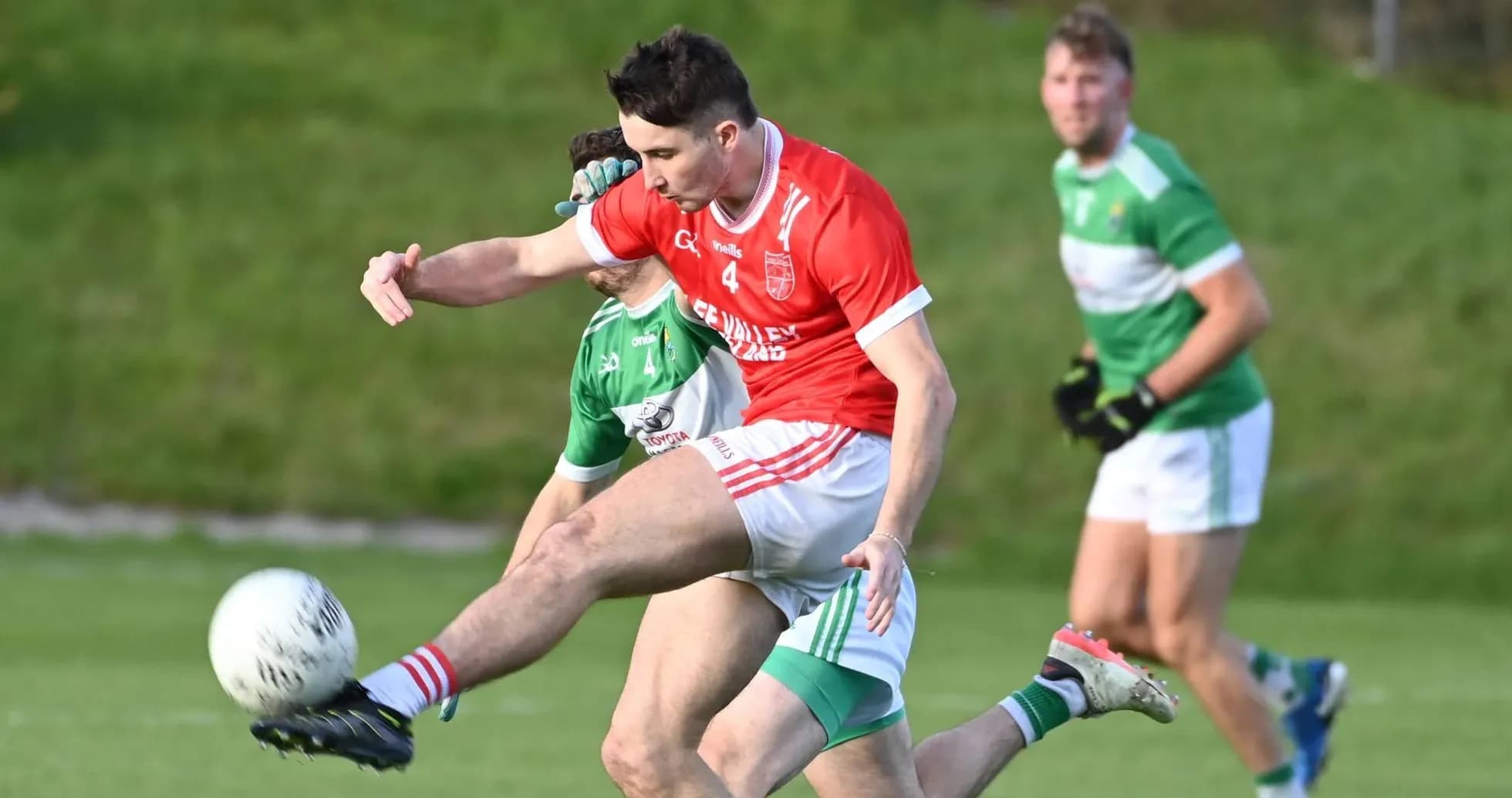 Player in red kicking ball during Gaelic football match
