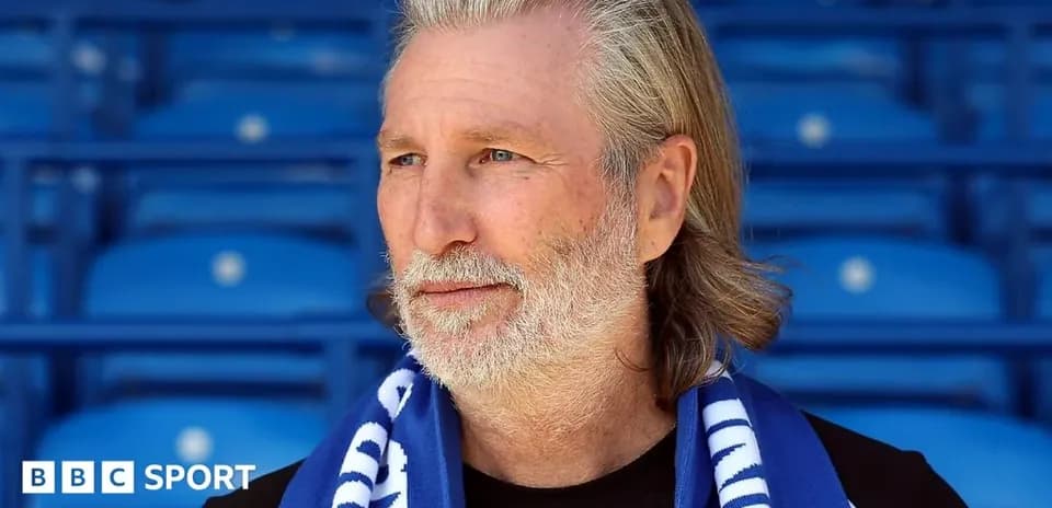 Man wearing scarf in empty stadium seating area
