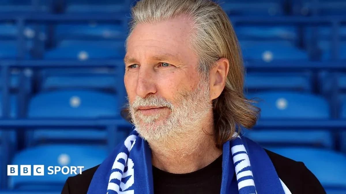 Man wearing scarf in empty stadium seating area