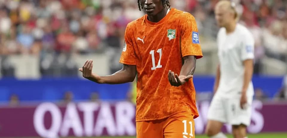 Player gesturing during match in orange jersey