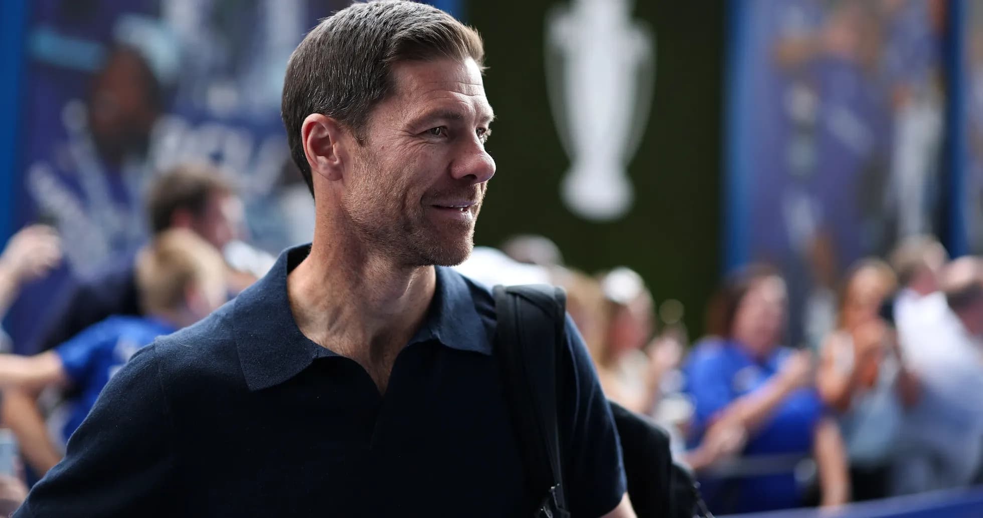 Man with short hair smiling in a crowd