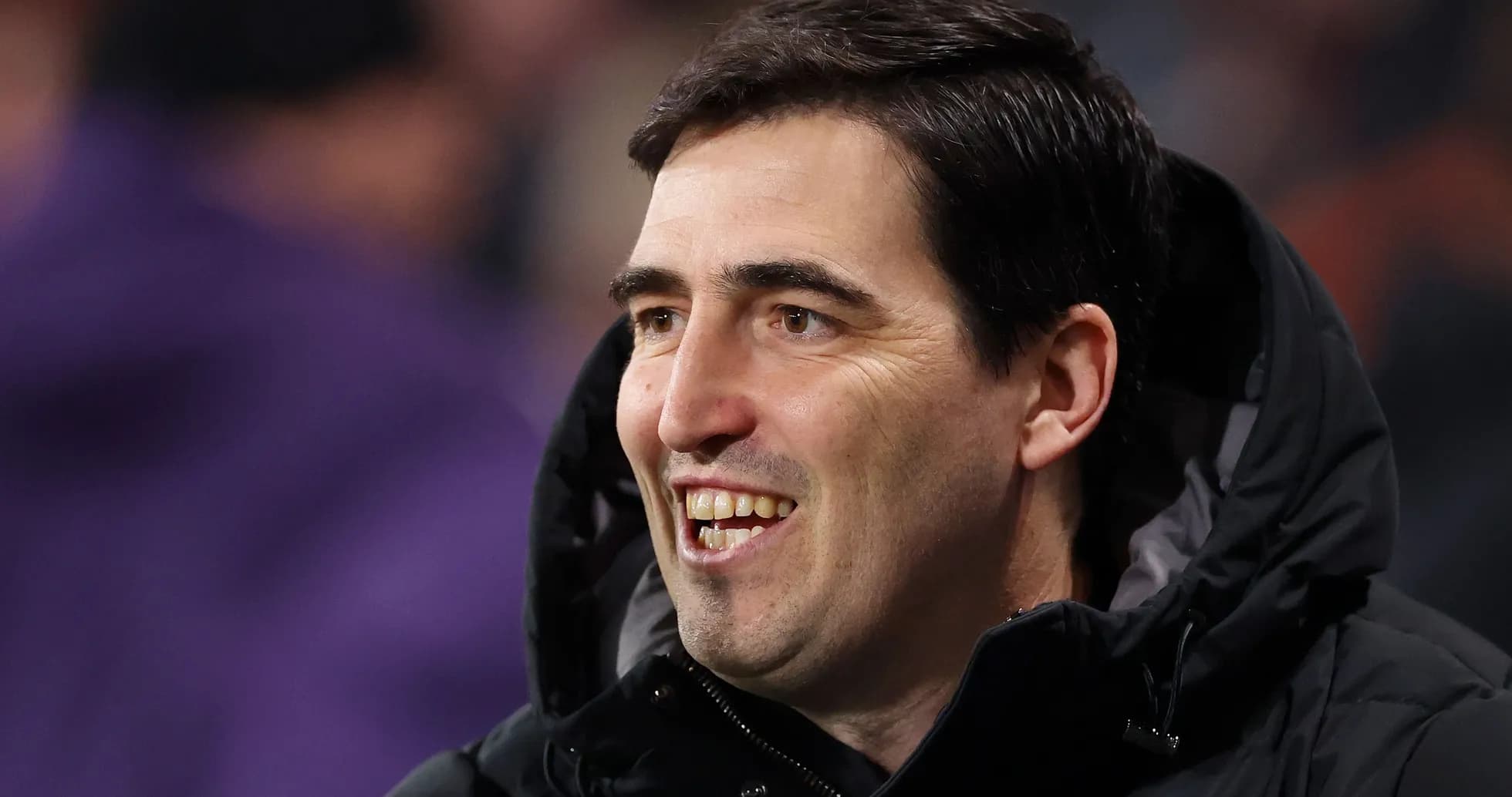 Coach smiling during a match on the sidelines