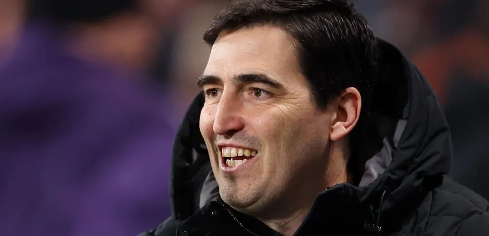 Coach smiling during a match on the sidelines