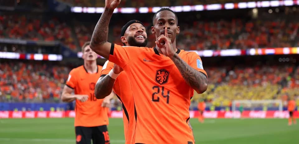 Players celebrating a goal in orange Netherlands jerseys