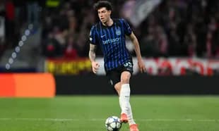 Player in blue and black kit dribbling football