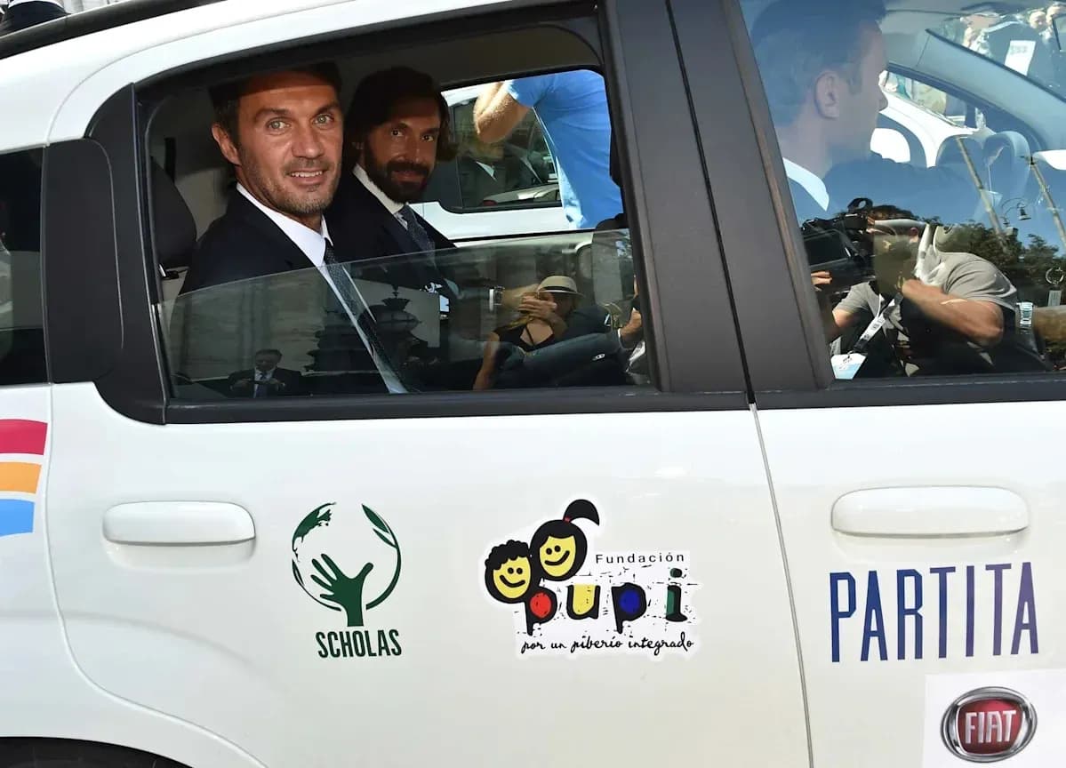 Two men in a car with charity logos visible