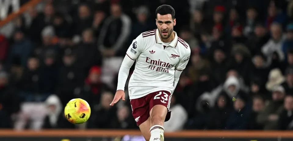 Player in Arsenal kit kicking a football during match