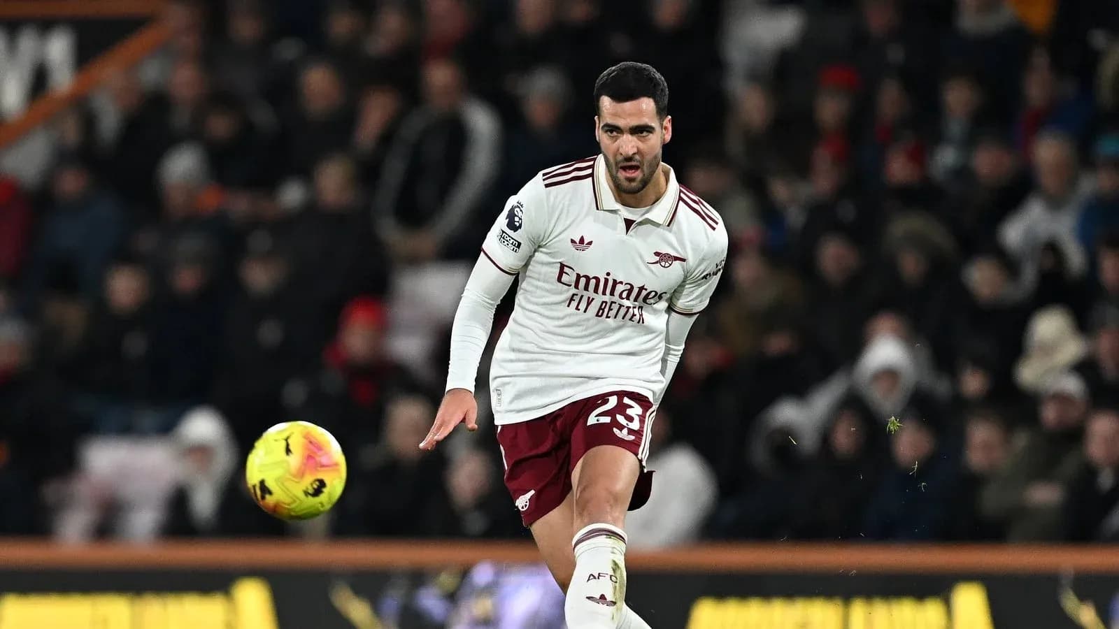 Player in Arsenal kit kicking a football during match