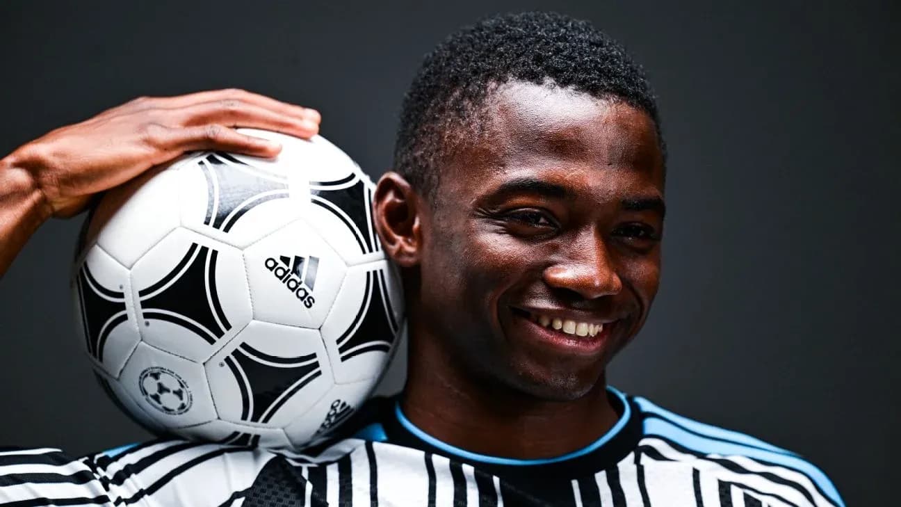 Player smiling while holding a soccer ball