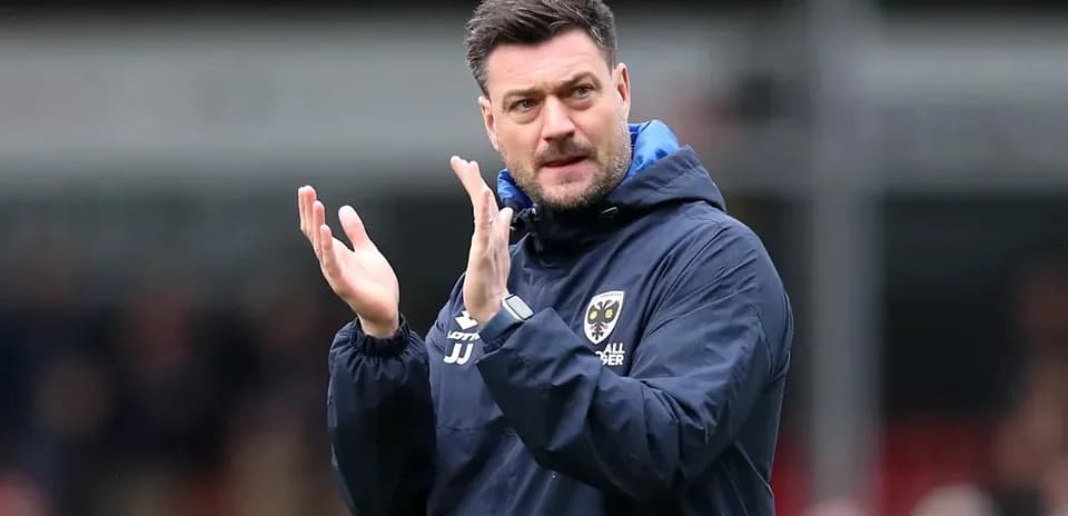 Manager applauding during a match on the sidelines