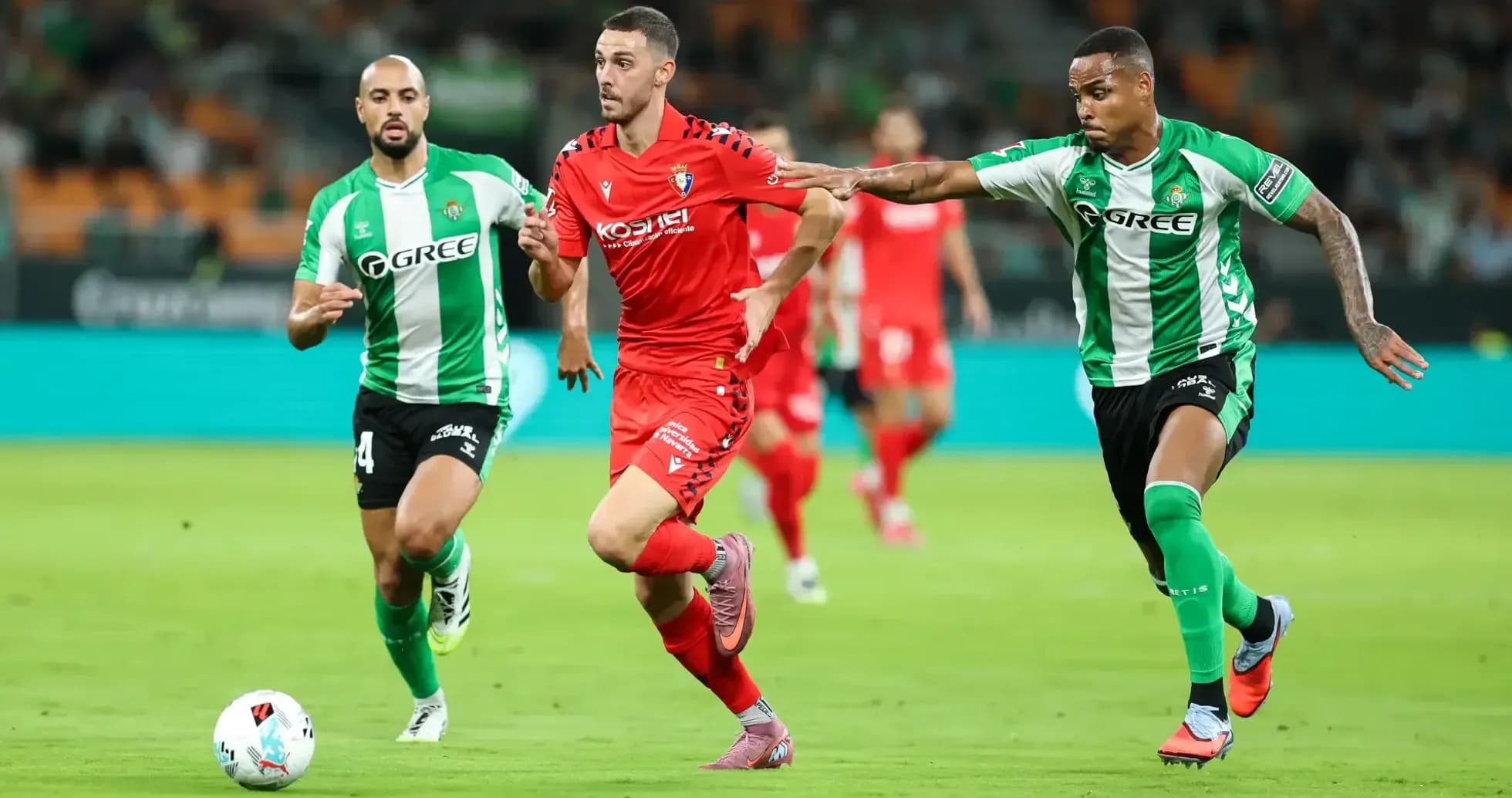 Osasuna player dribbling past Real Betis defenders