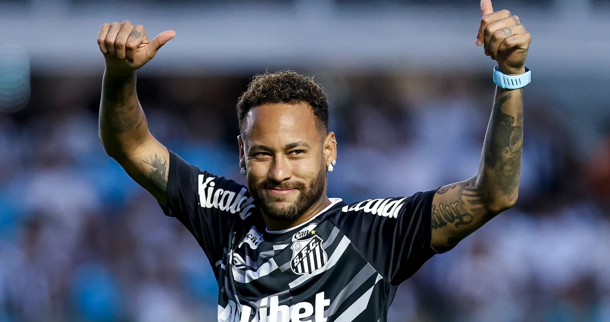 Player celebrating with thumbs up in Santos jersey