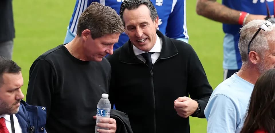 Two men conversing on the pitch before match
