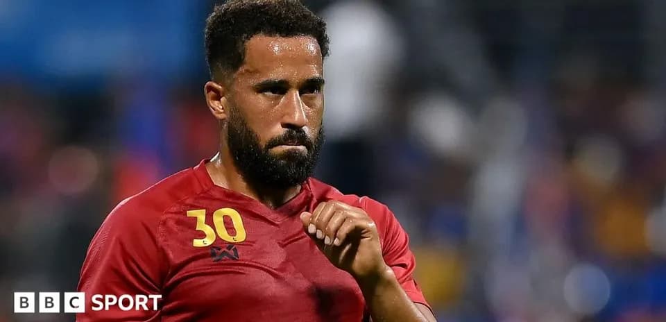 Player in red jersey during match, focused expression