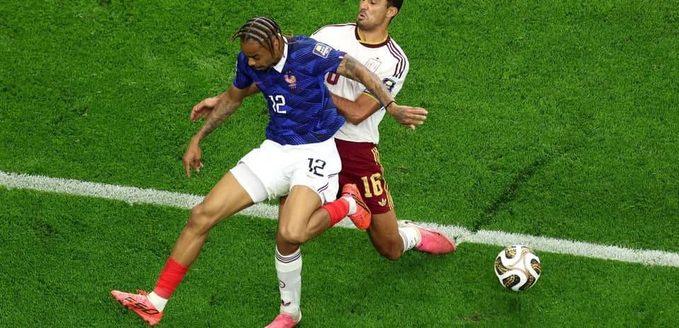 Two players competing for the ball on field