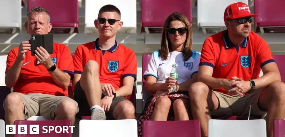 Fans wearing England jerseys seated in stadium