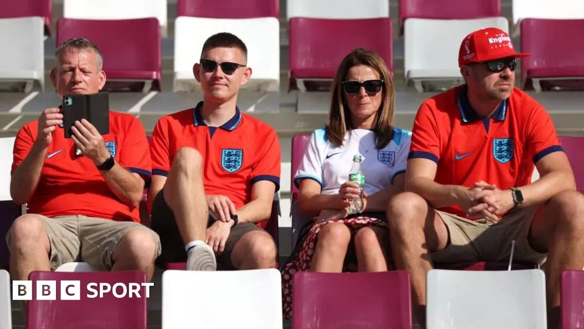 Fans wearing England jerseys seated in stadium