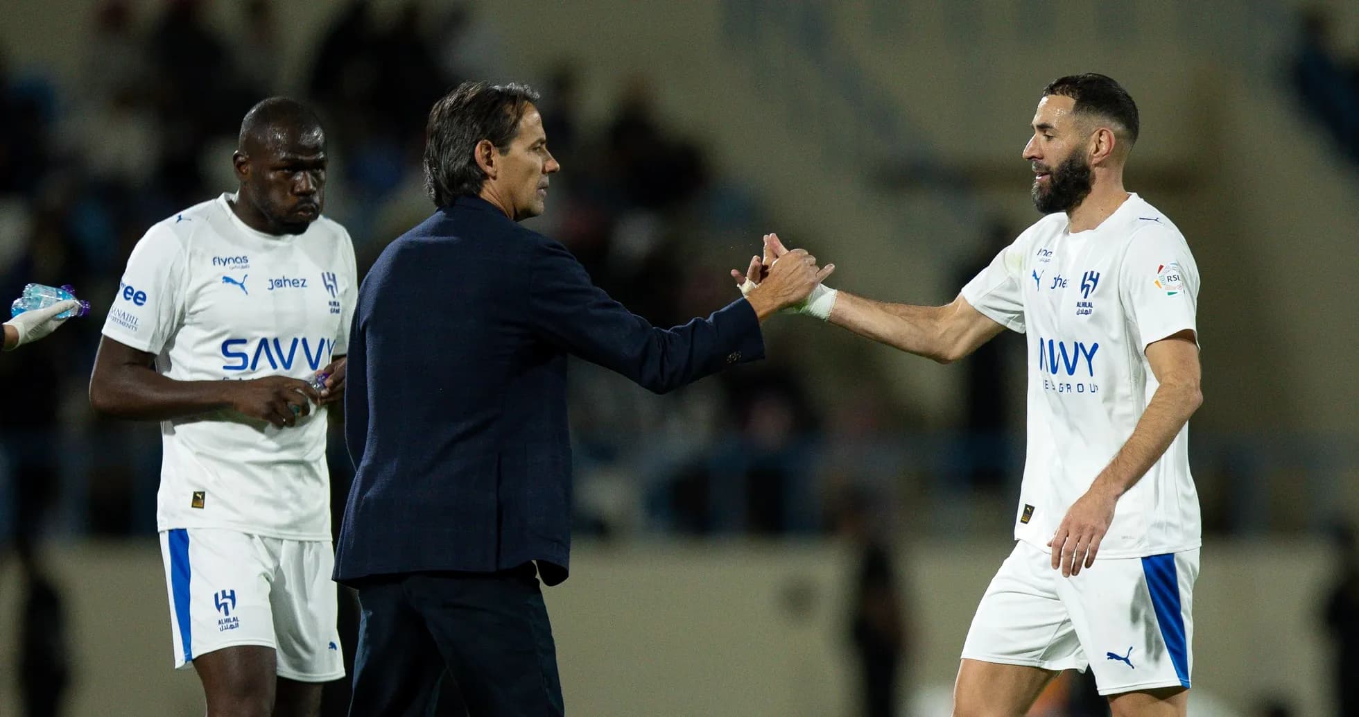 Coach shaking hands with player during match substitution