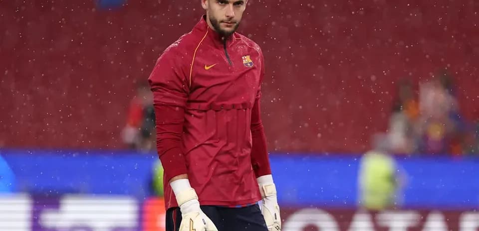 Goalkeeper in red jersey warming up in rain