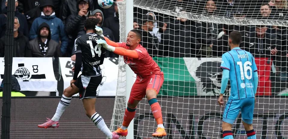 Goalkeeper attempting to save a shot during match