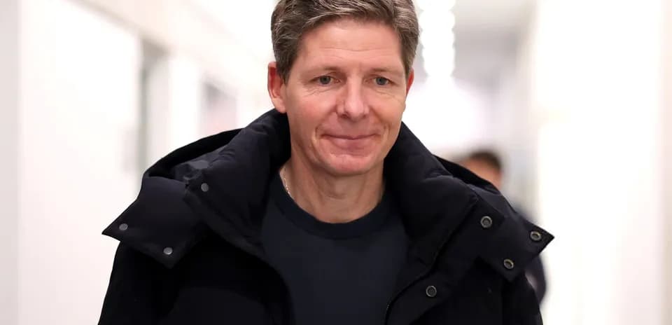 Man walking in a hallway wearing a black jacket