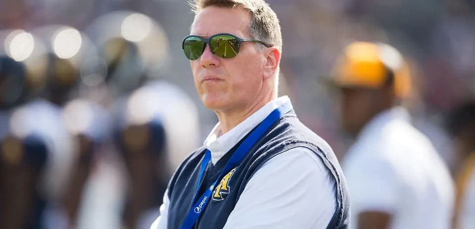 Man wearing sunglasses observing a football game