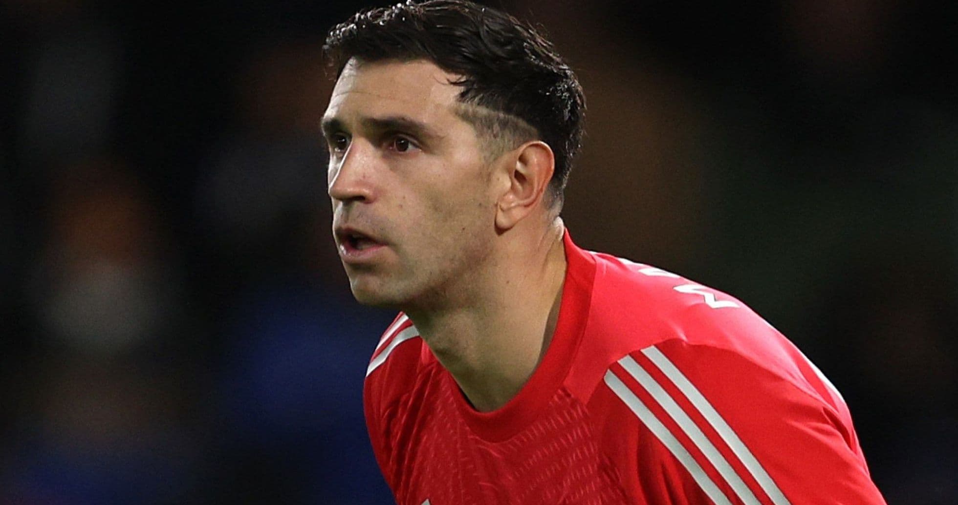 Goalkeeper in red kit focused during match