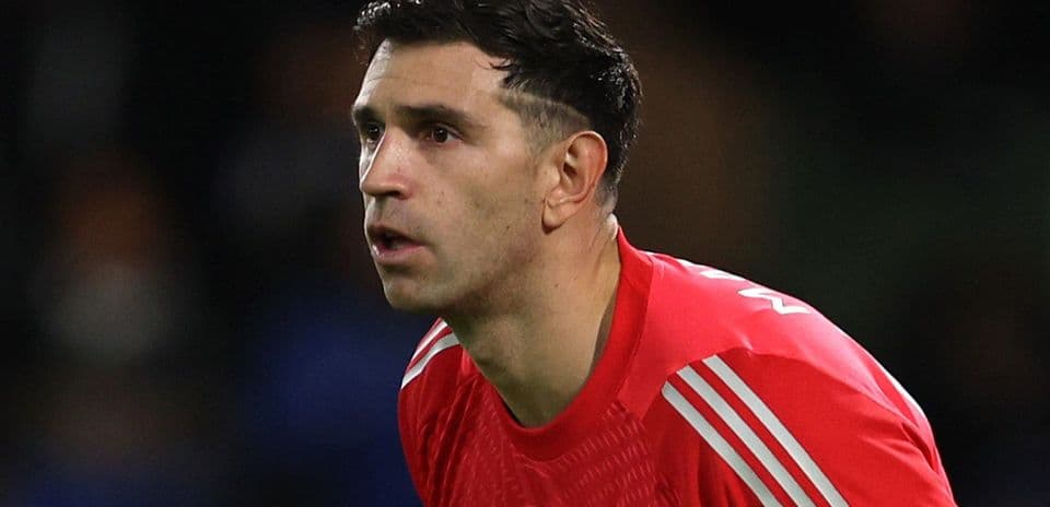 Goalkeeper in red kit focused during match
