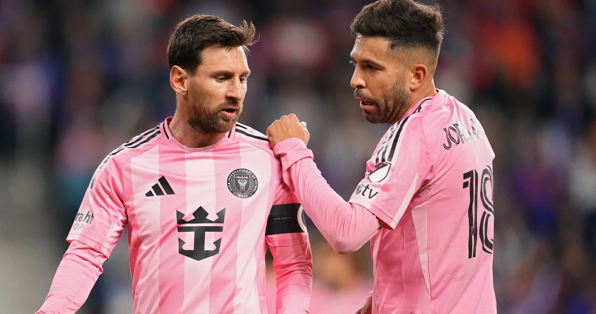 Two players discussing during a match in pink uniforms