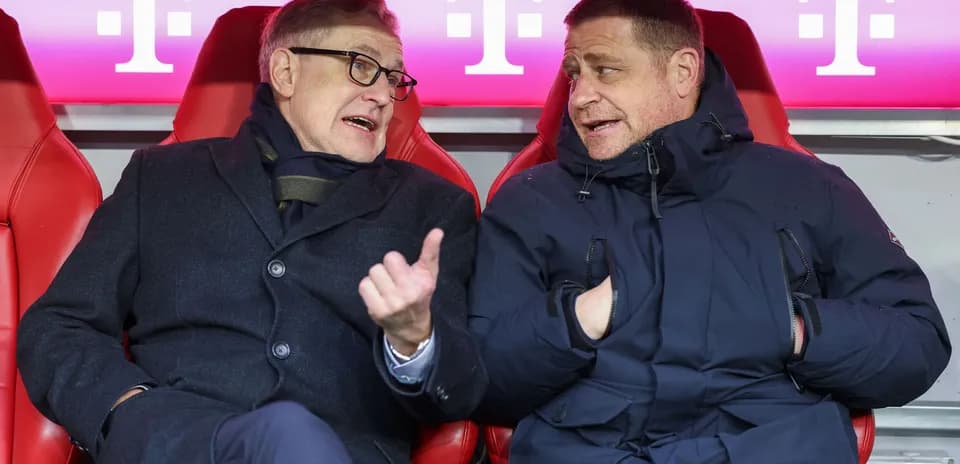 Two men conversing on team bench during match