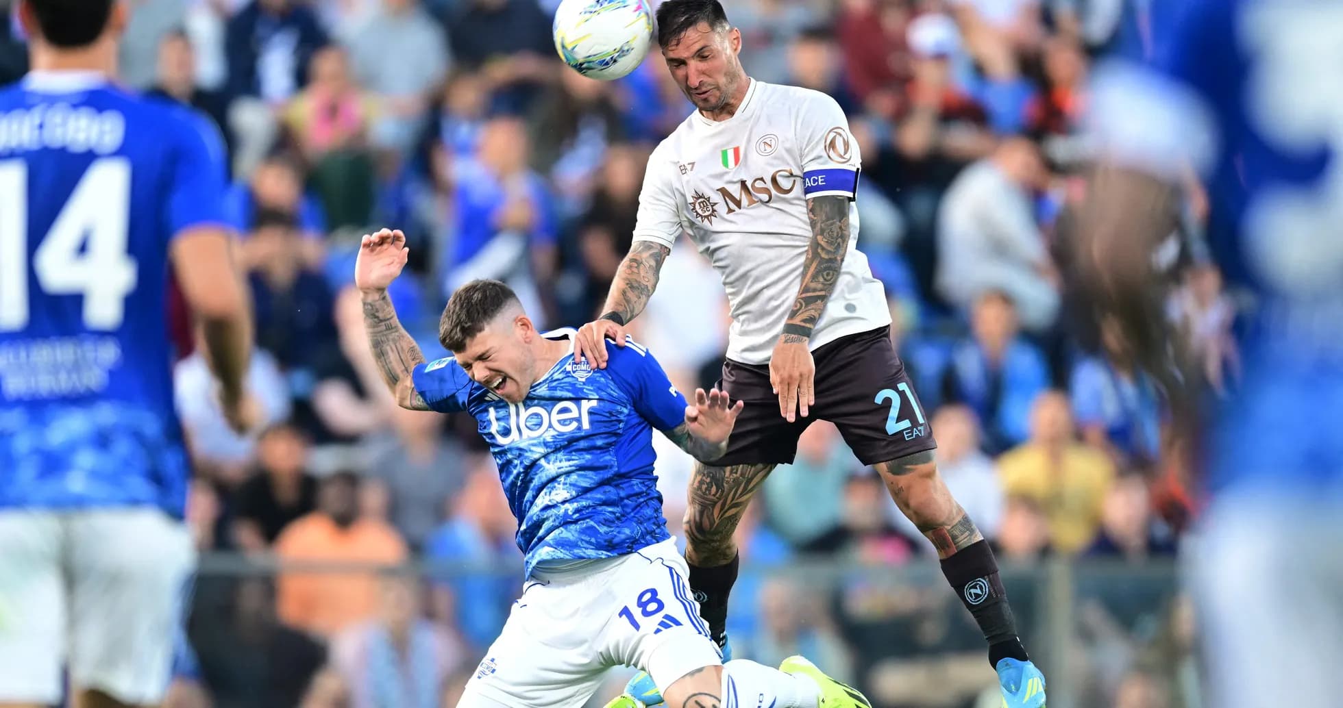 Napoli player challenging Como player for the ball