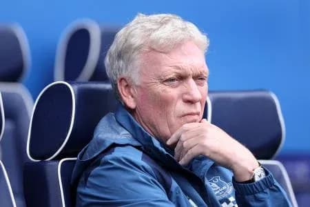 Manager seated on bench during match