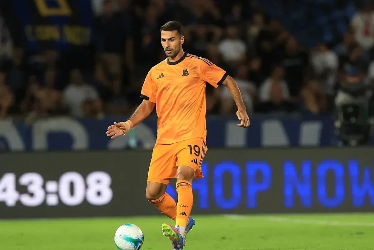 Player in orange kit dribbling a soccer ball