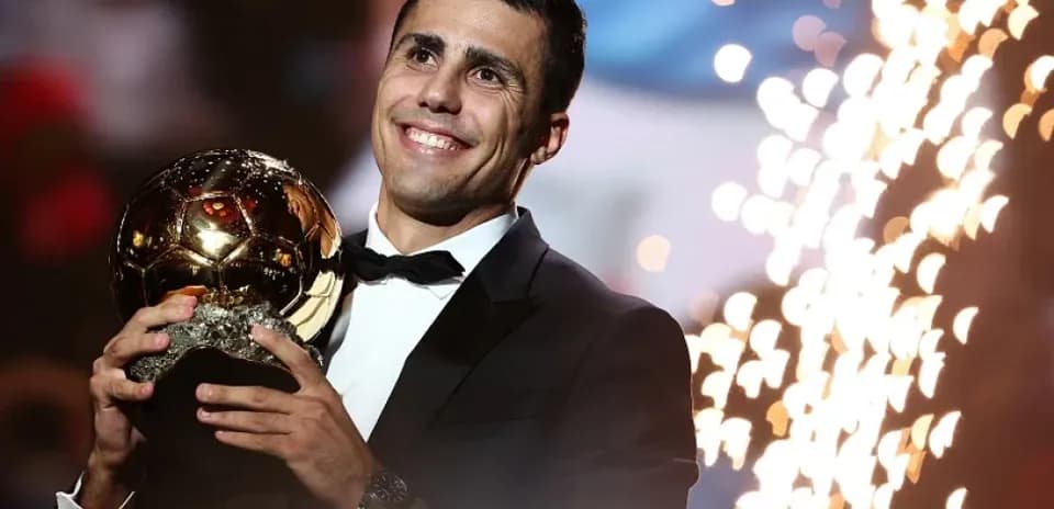 Player holding Ballon d'Or trophy at ceremony