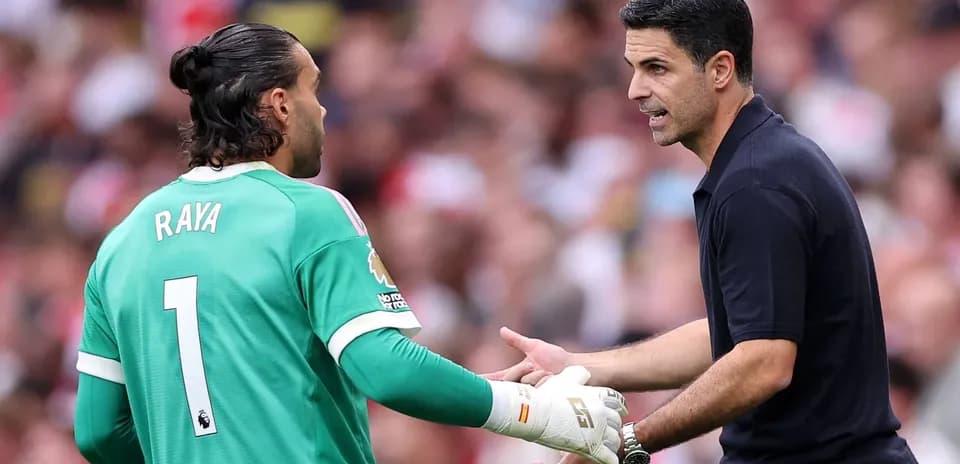 Goalkeeper conversing with manager on the field