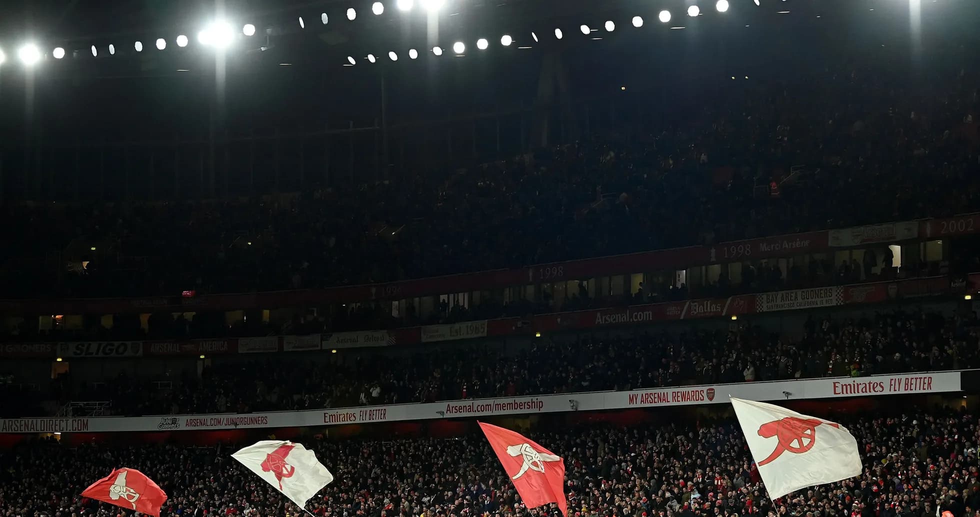 Arsenal fans waving flags in packed stadium
