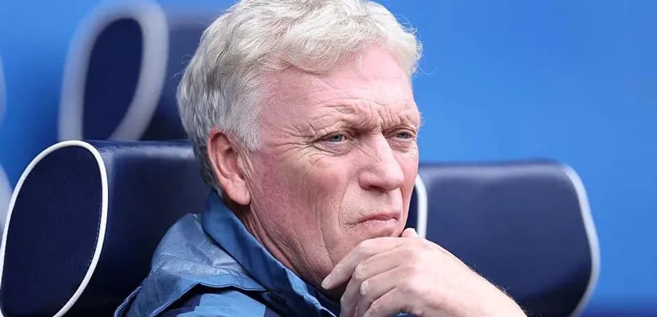 Coach seated on bench during match