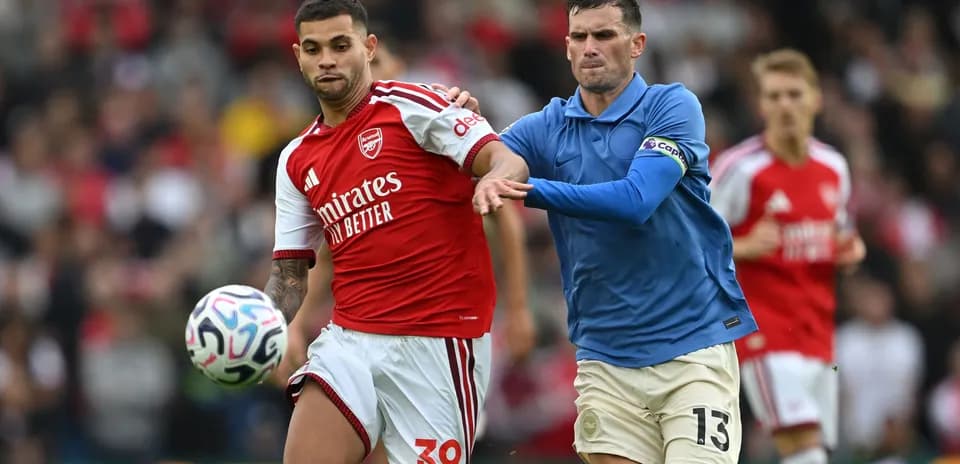 Player in red and player in blue contesting ball