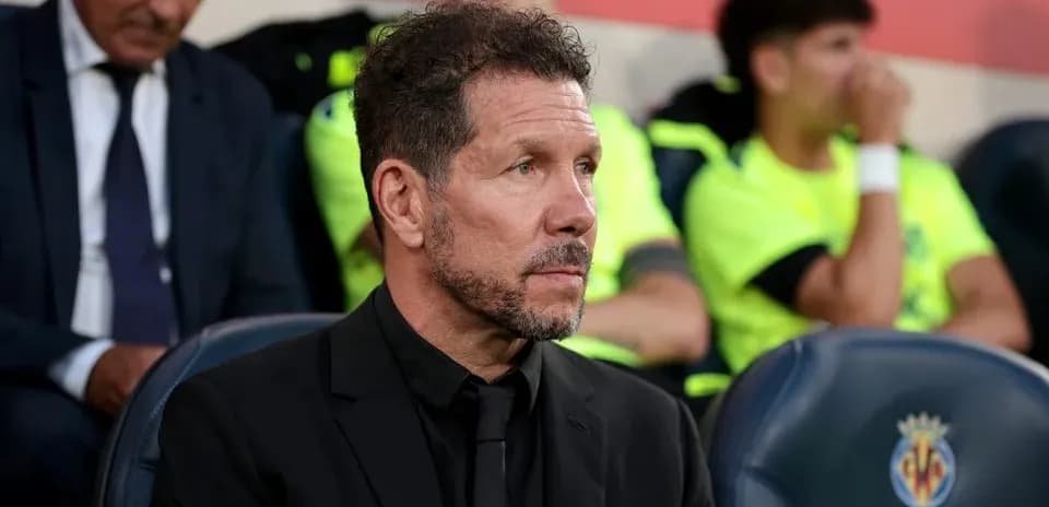 Coach sitting on bench during match at stadium