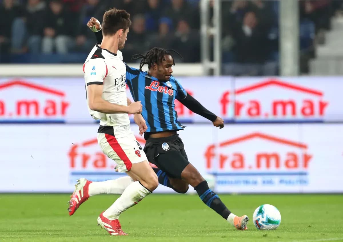 AC Milan player challenged by Atalanta opponent