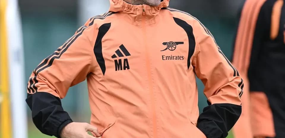 Coach smiling during training session in Arsenal jacket