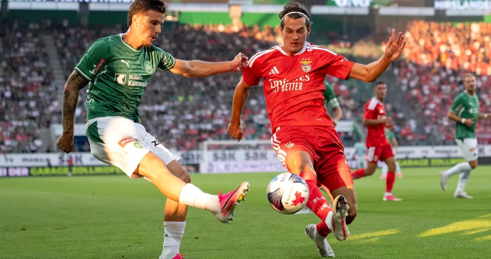 Benfica player challenging FC St. Gallen opponent