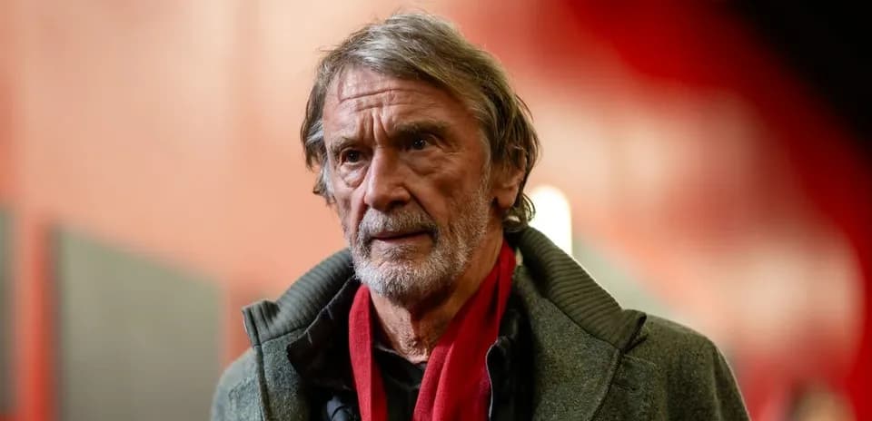Man wearing a gray coat and red scarf indoors