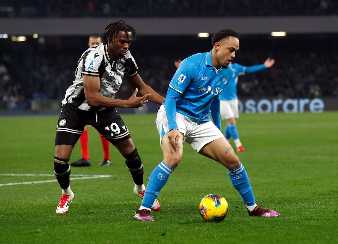 Napoli player dribbling against Udinese opponent