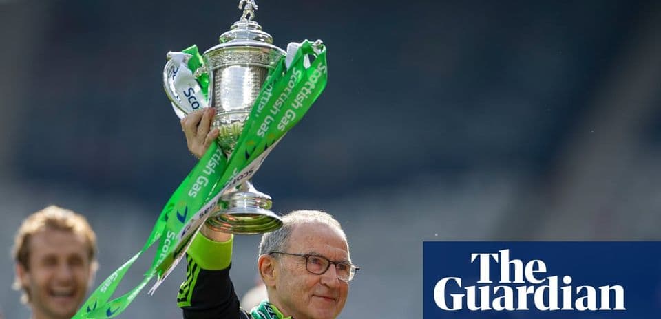 Manager holding trophy with green ribbons after victory